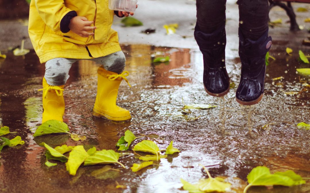 Children splashing in wet puddles