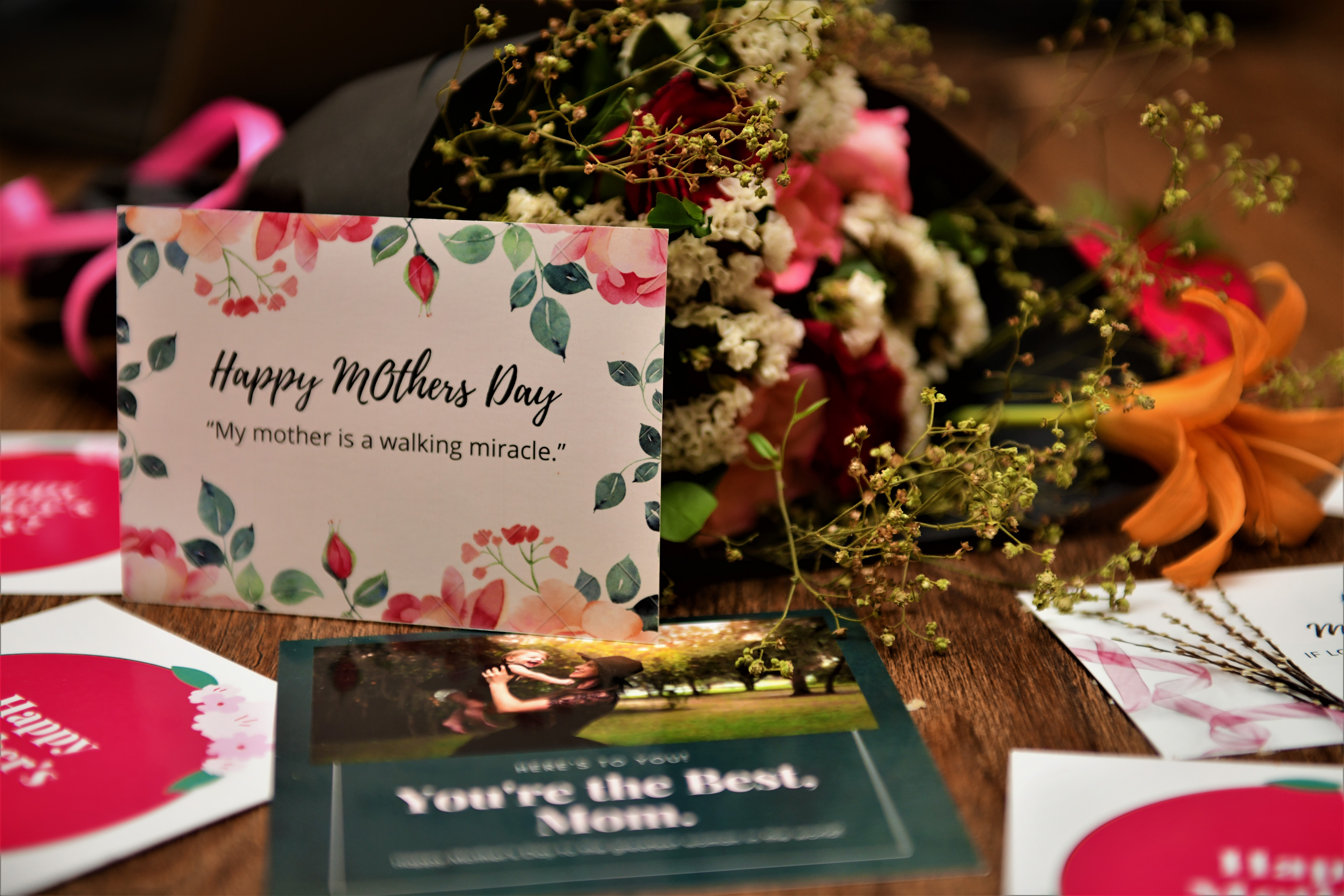 Card saying 'Happy Mother's Day' and flowers on a table